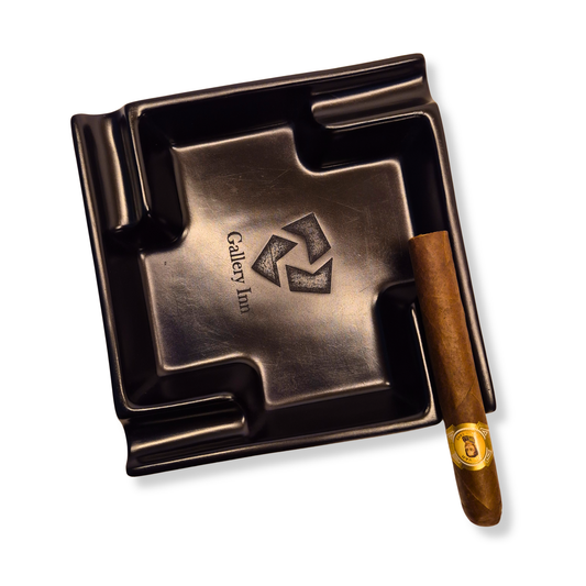 Bronze ashtray with a logo and a cigar on a white background
