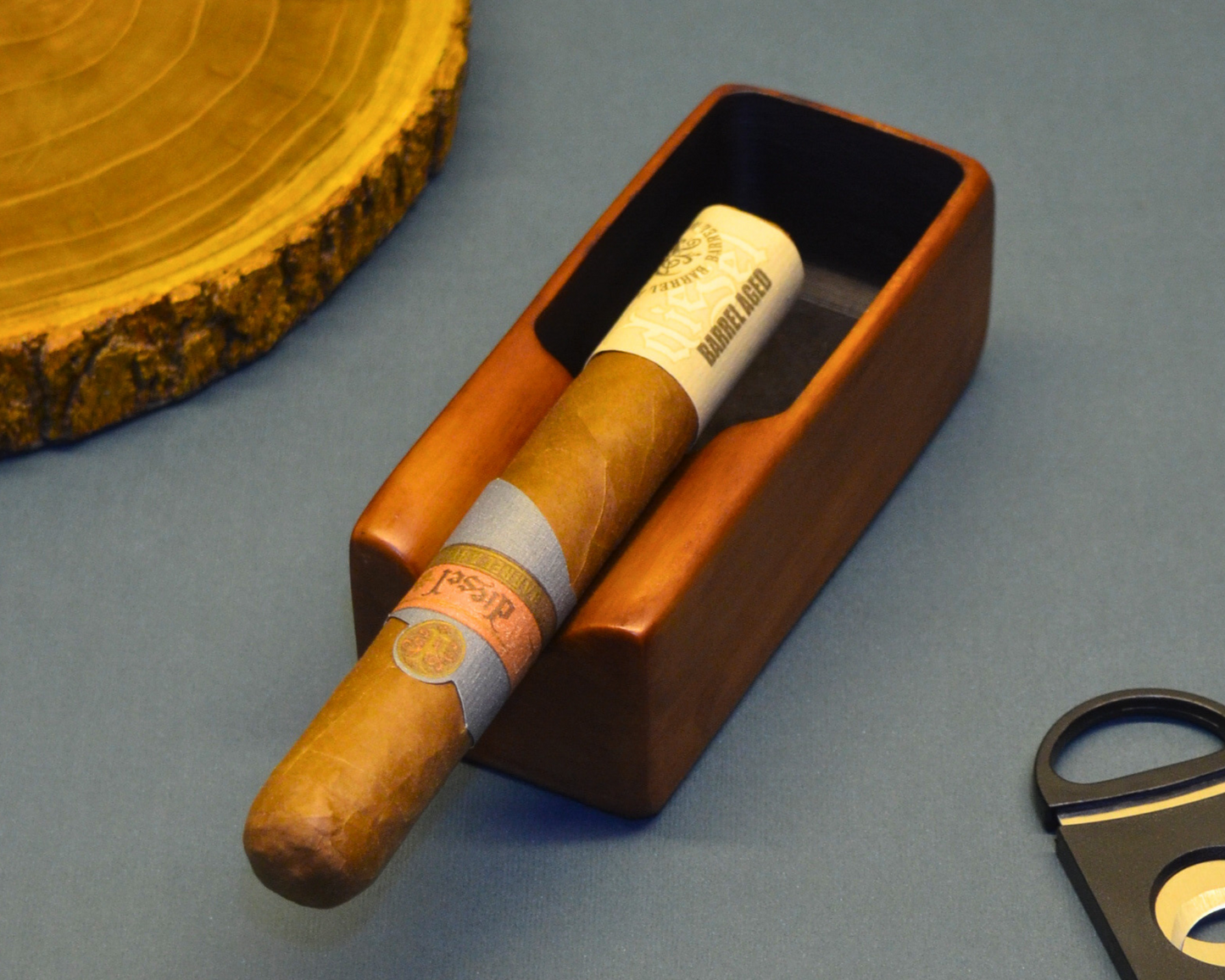 Cigar in a wooden holder with a cutter on a gray surface