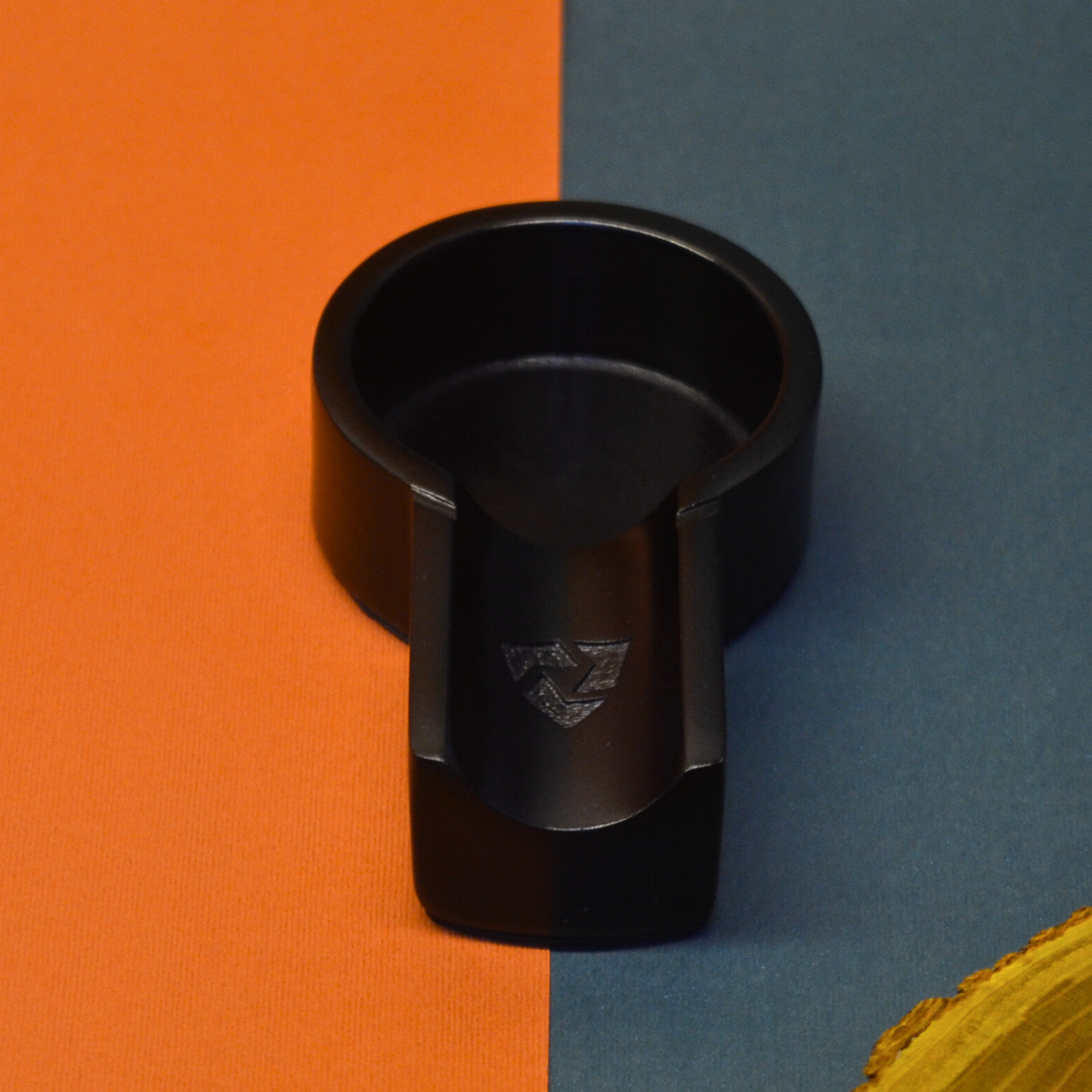 Black cup holder on an orange and blue background