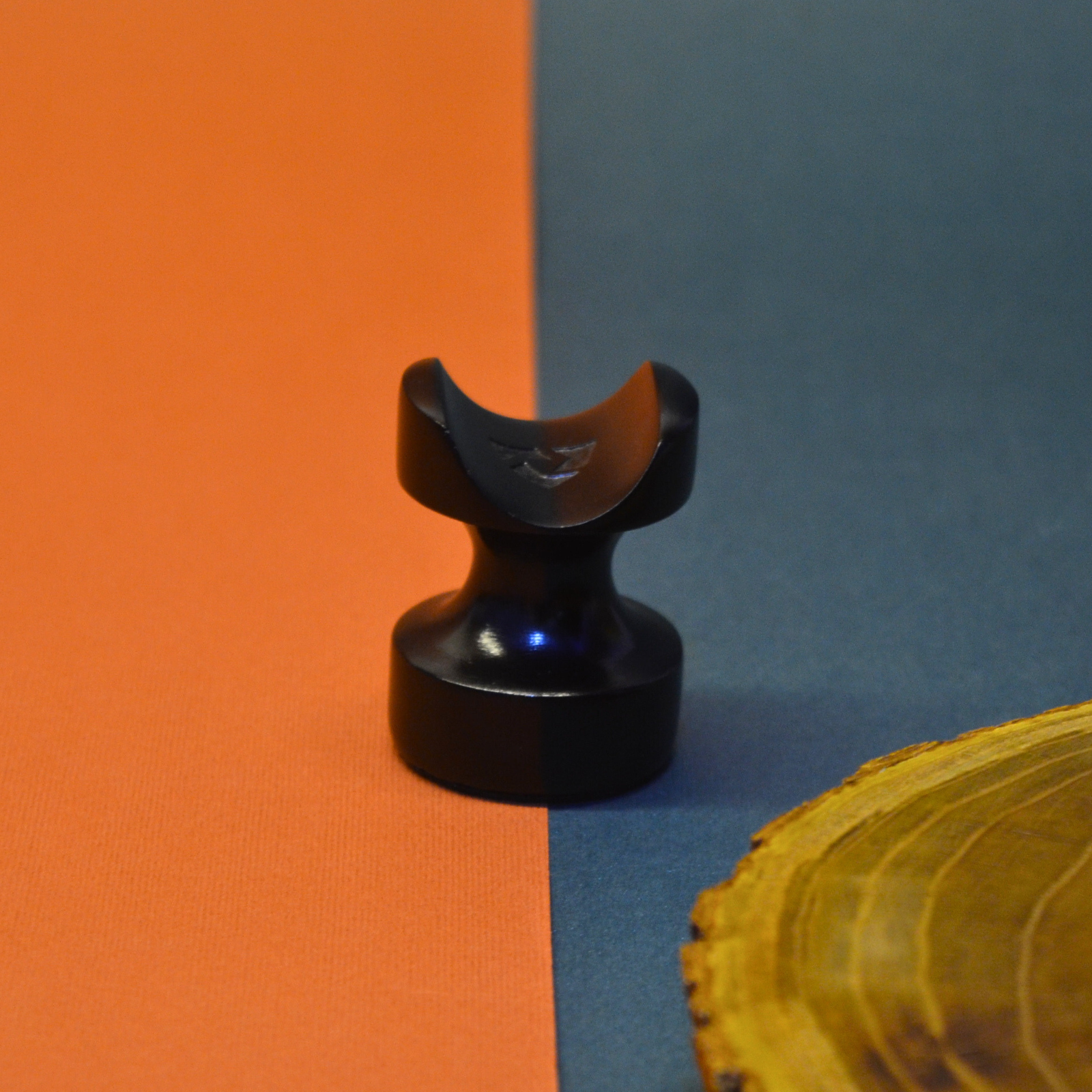 Black decorative object on an orange and blue background