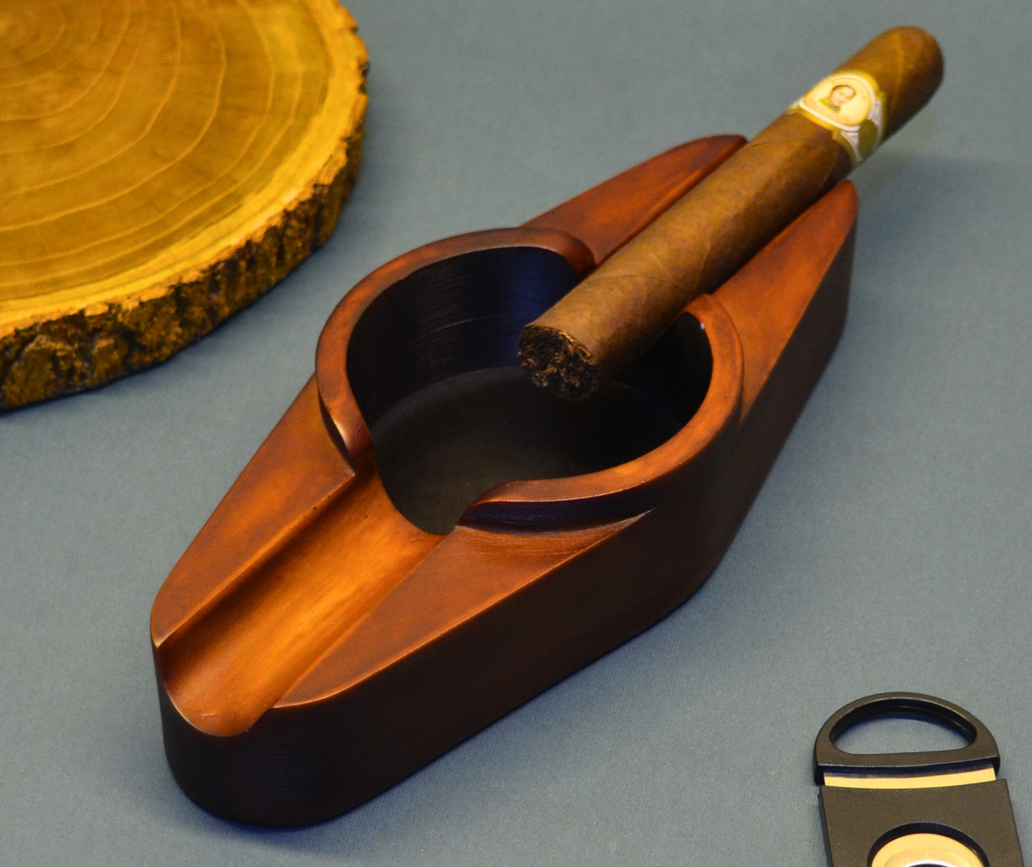 A cigar ashtray with two cigar rests and a round ash hole (brown)