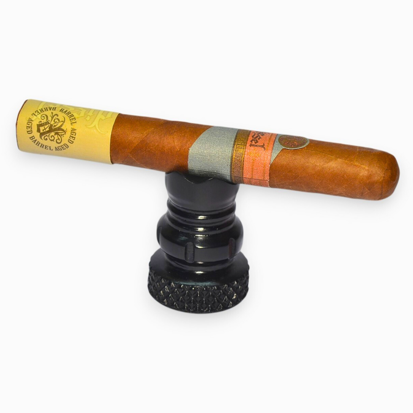 Cigar with a yellow band on a black stand against a white background