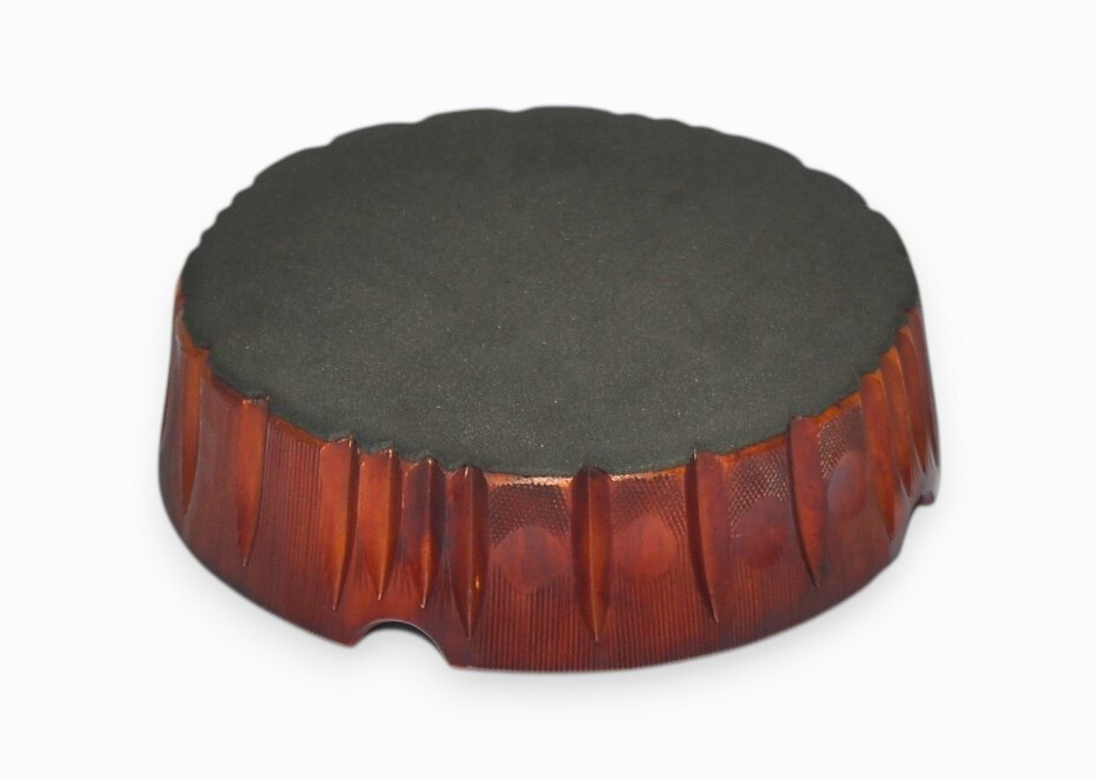 Round wooden object with a textured surface on a white background