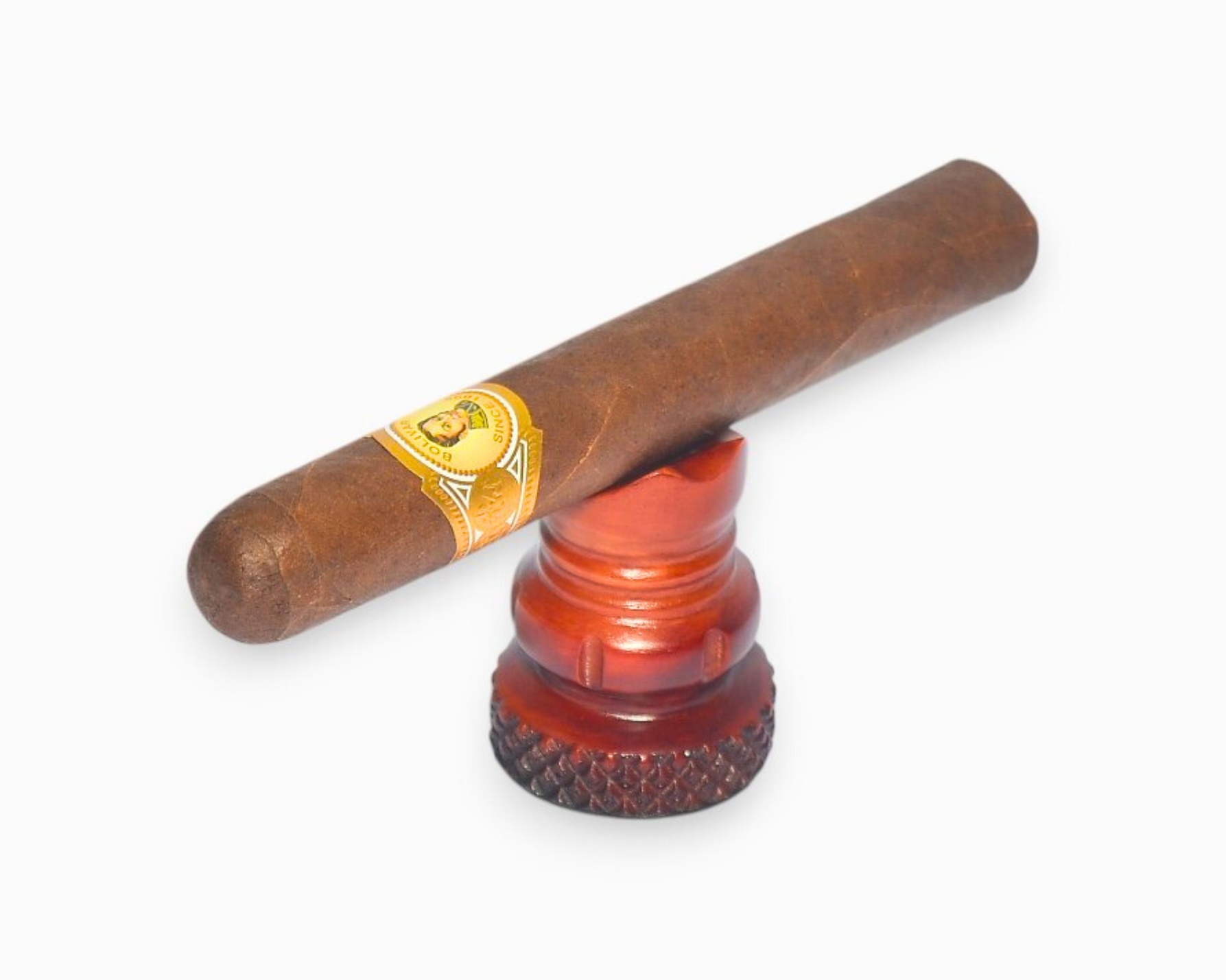 Cigar with a band on a red and black humidor against a white background