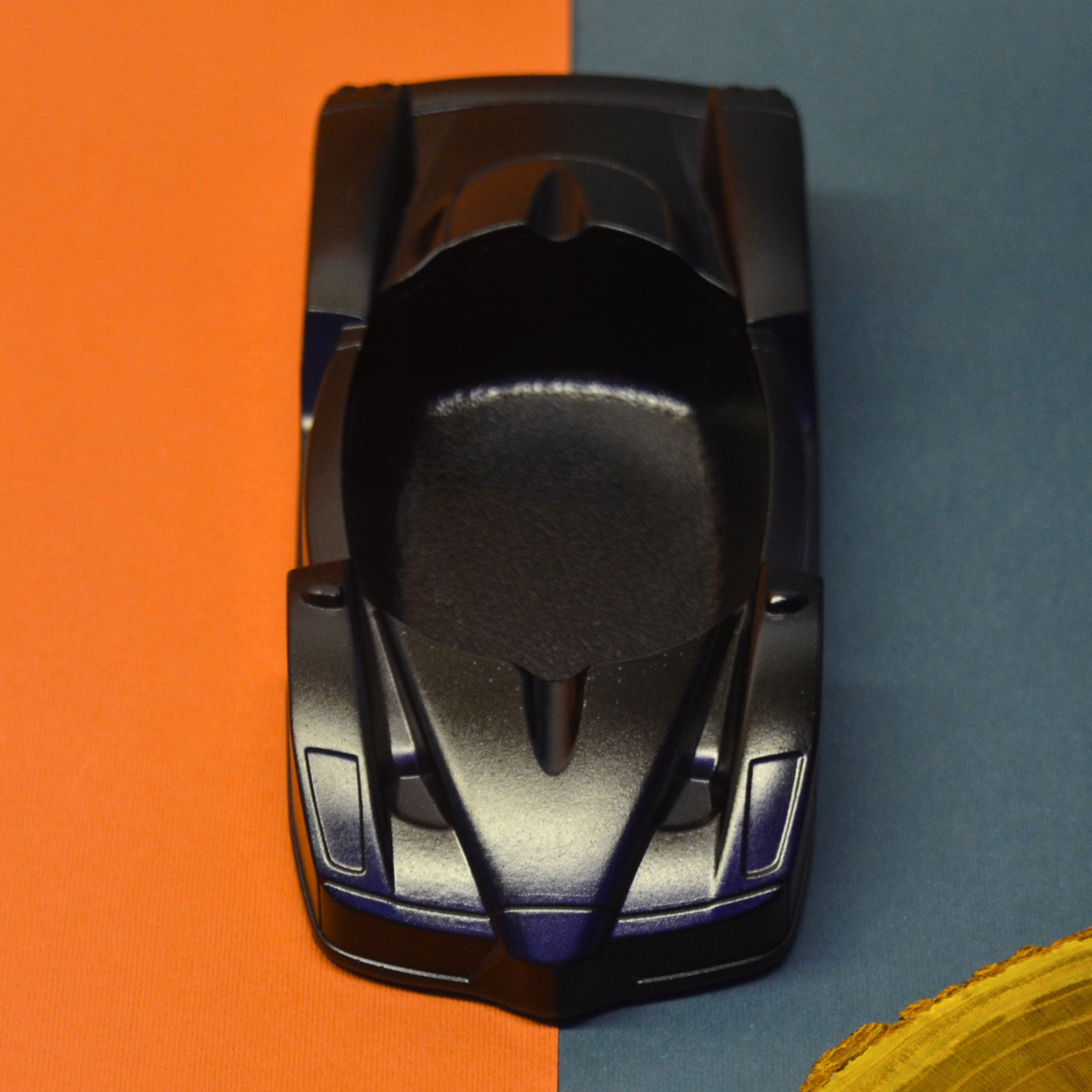 Black ashtray car on an orange and blue background