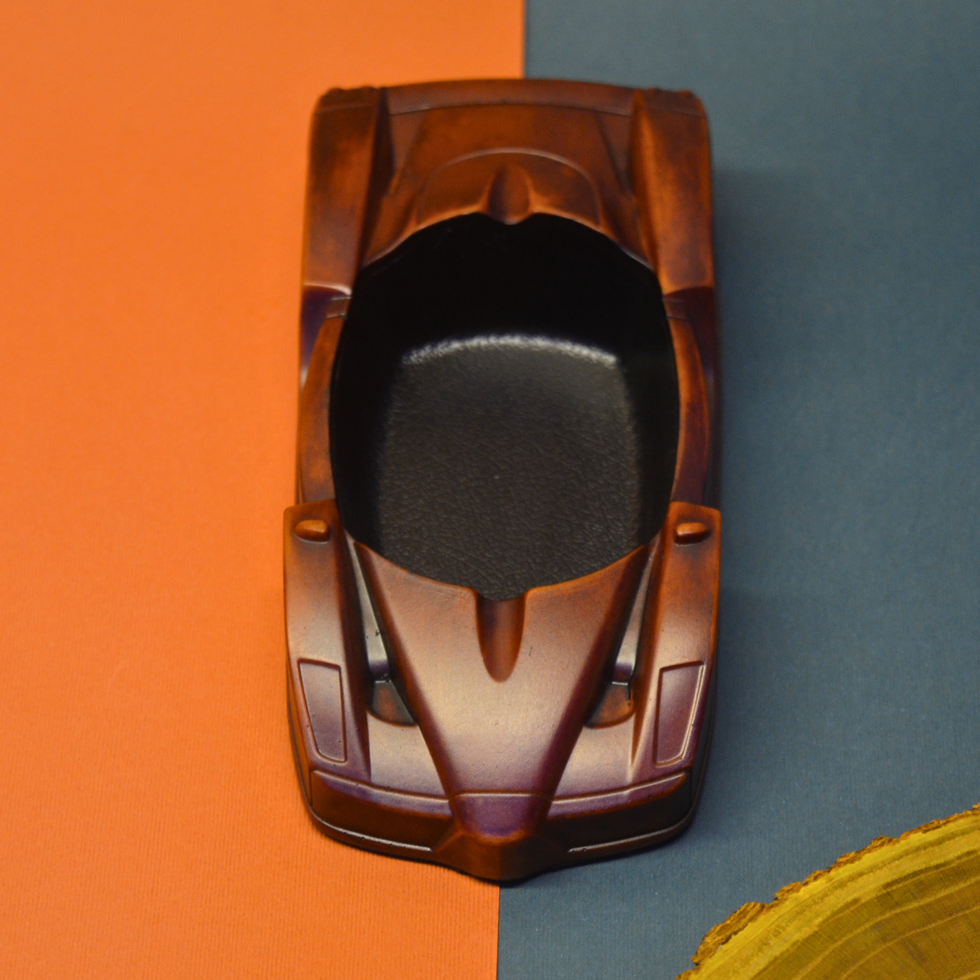 Wooden ashtray model on a two-tone orange and blue background