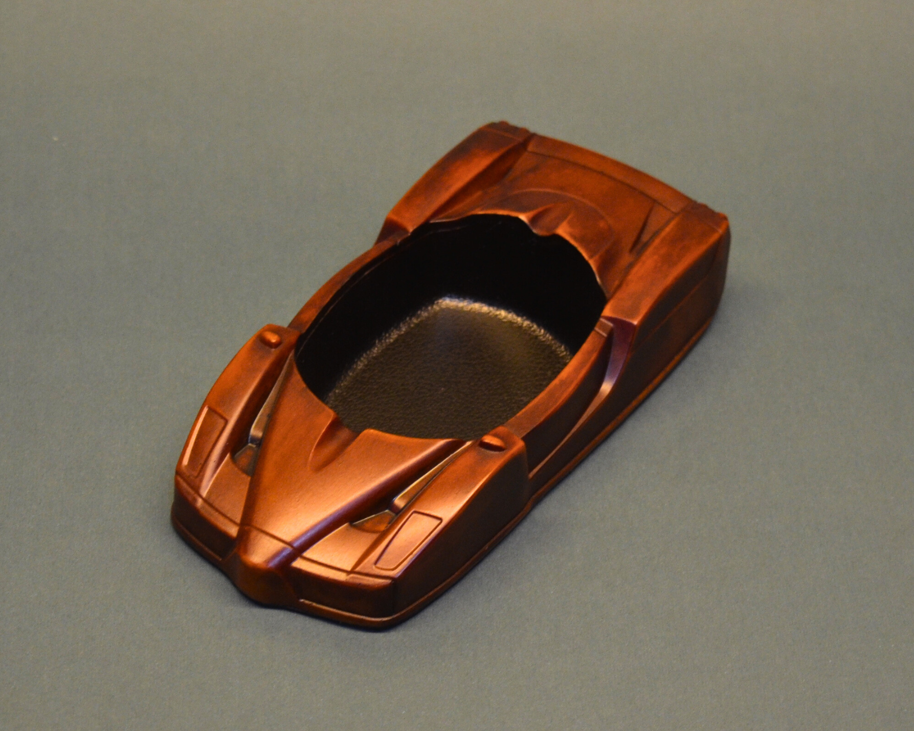 brown-ashtray car-shaped object on a gray background