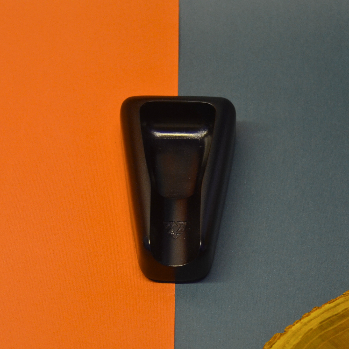 Black ashtray on an orange and gray background