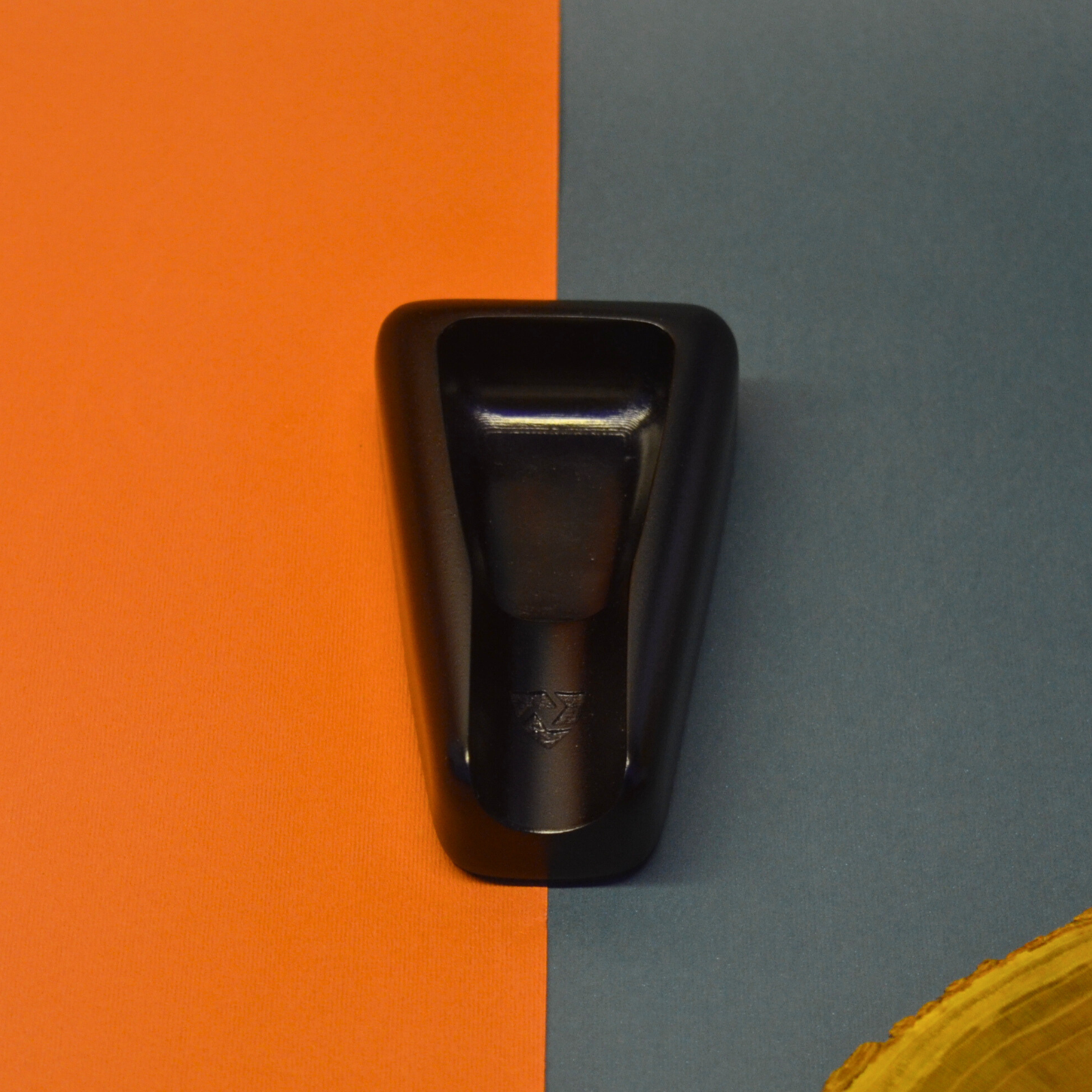 Black ashtray on an orange and gray background