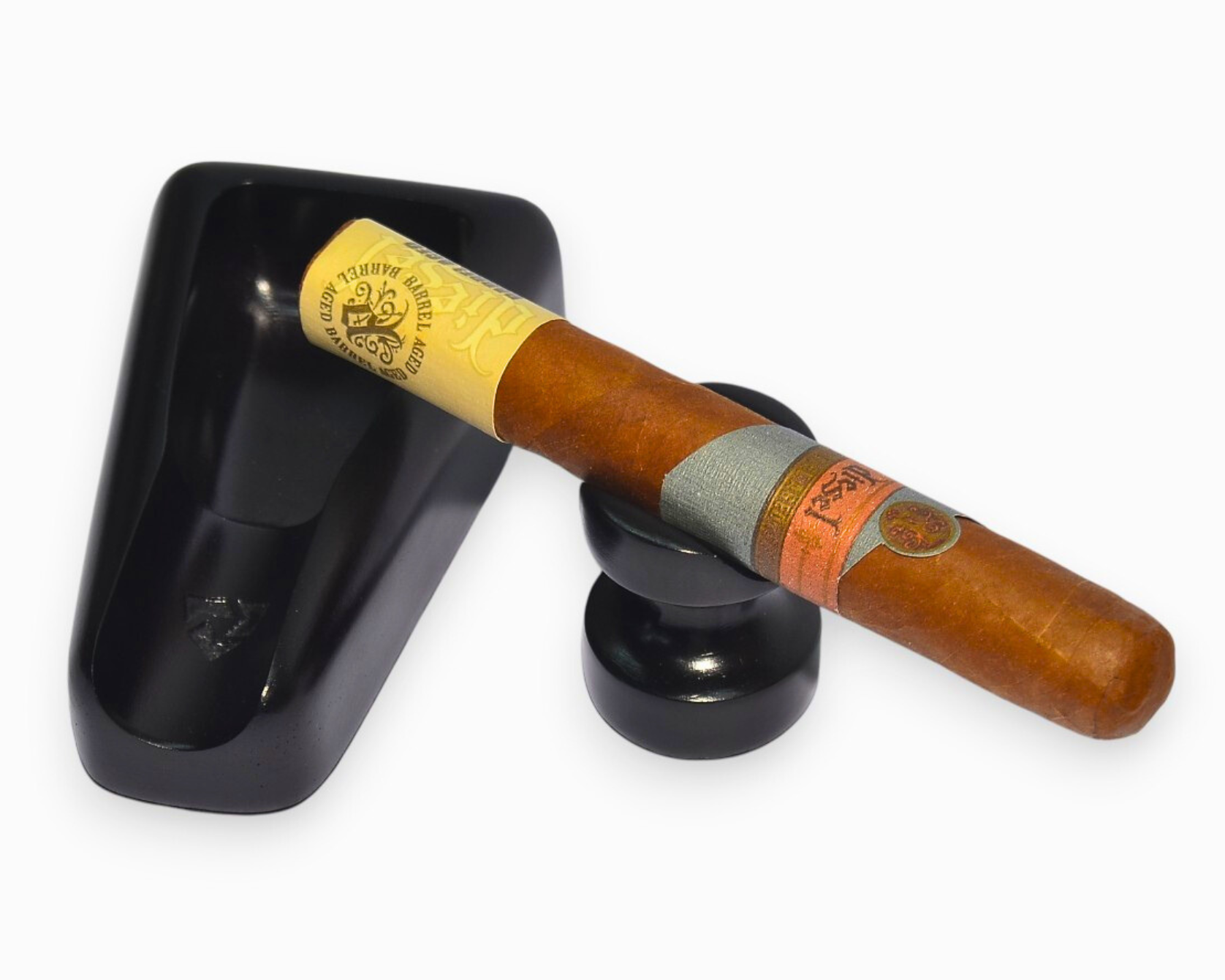 Cigar with a visible label on a black ashtray against a white background