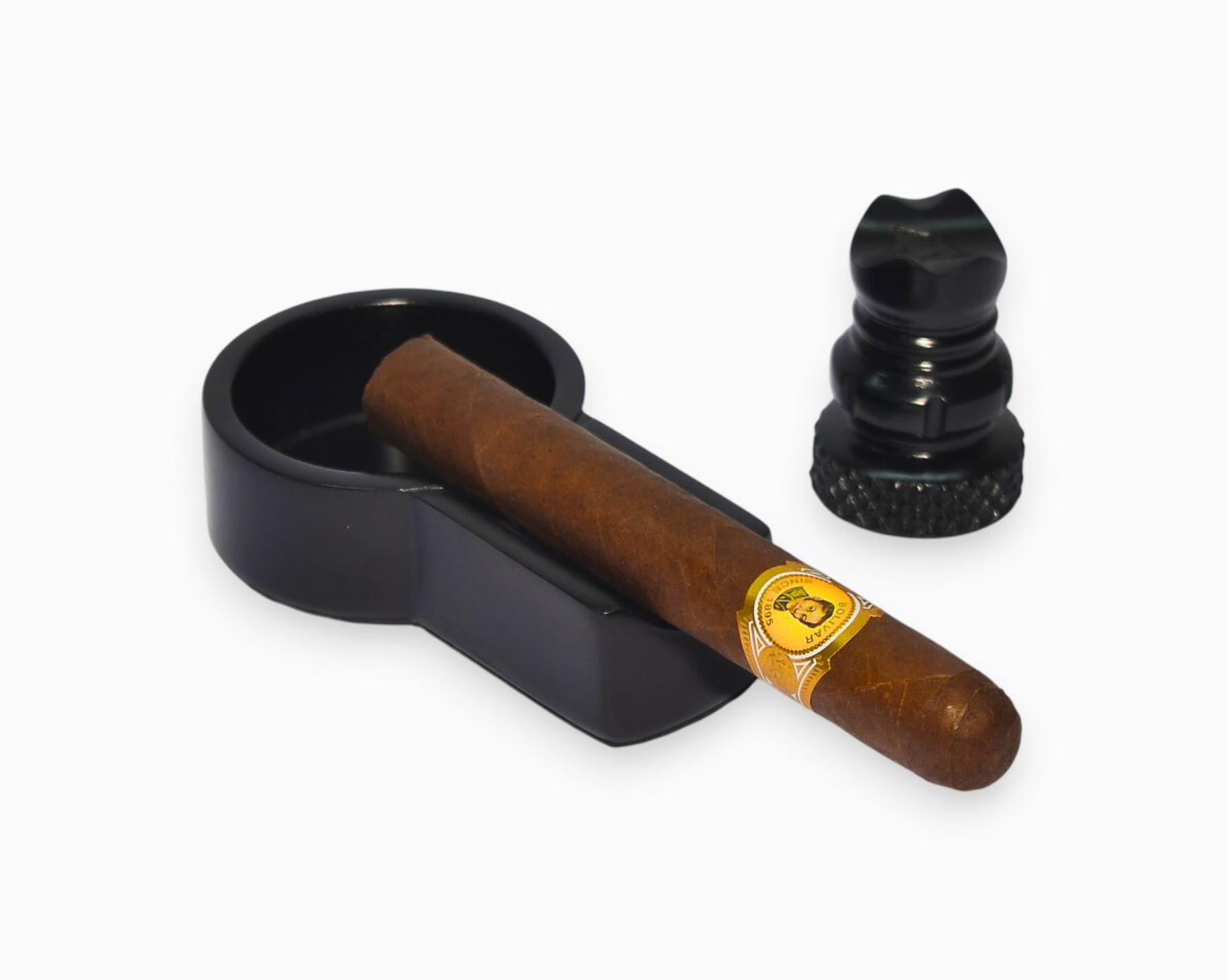 Cigar with a black holder and a black ashtray on a white background