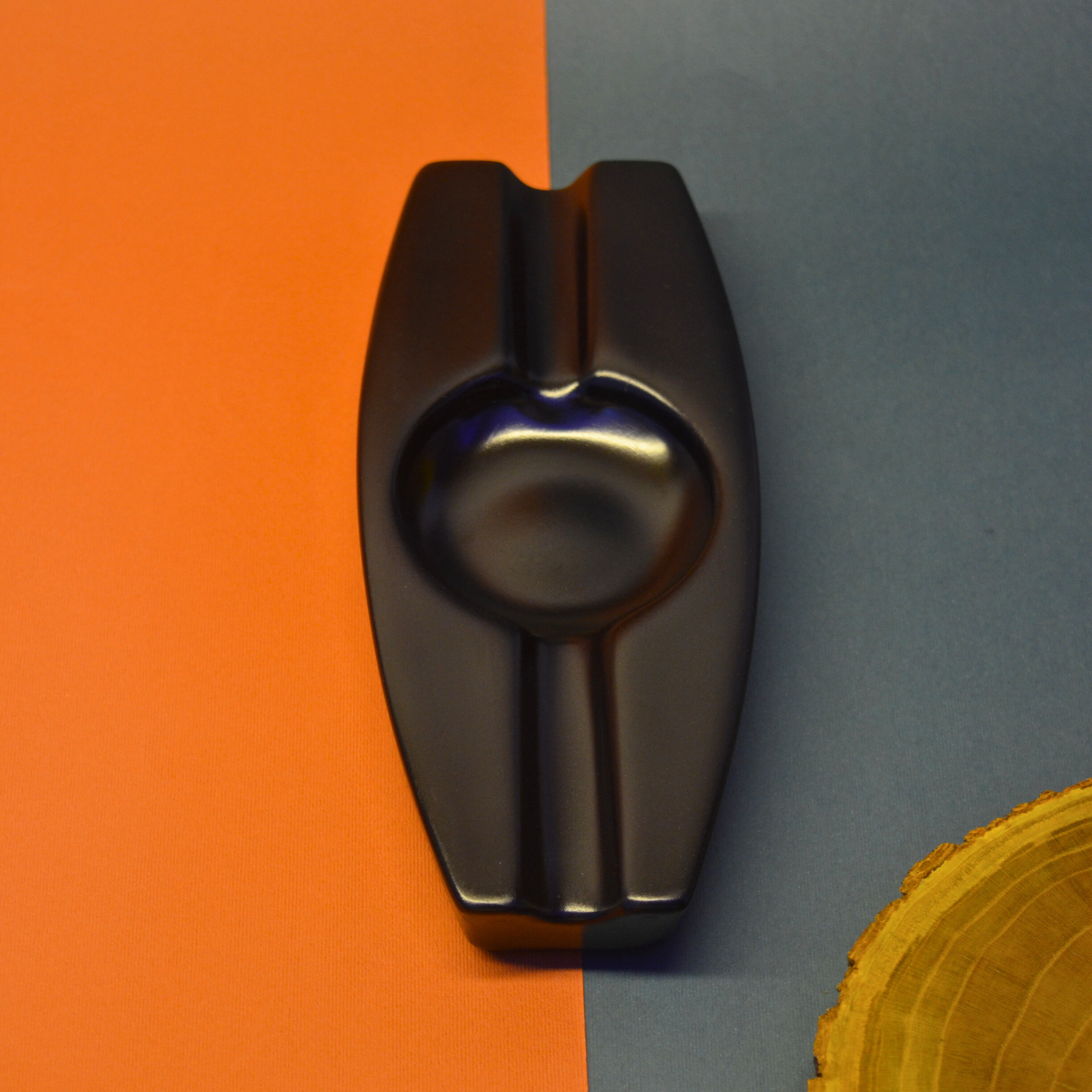 Black ashtray clip on an orange and gray background
