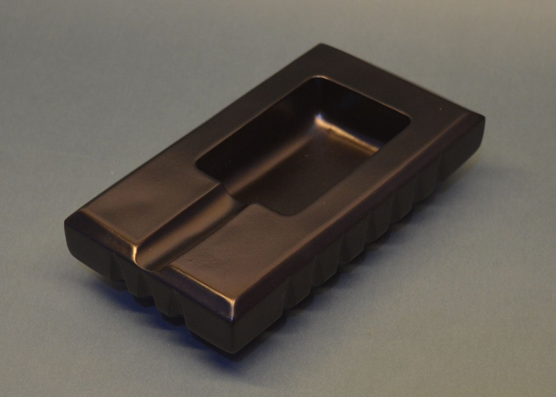 Bronze-colored rectangular object on a gray background