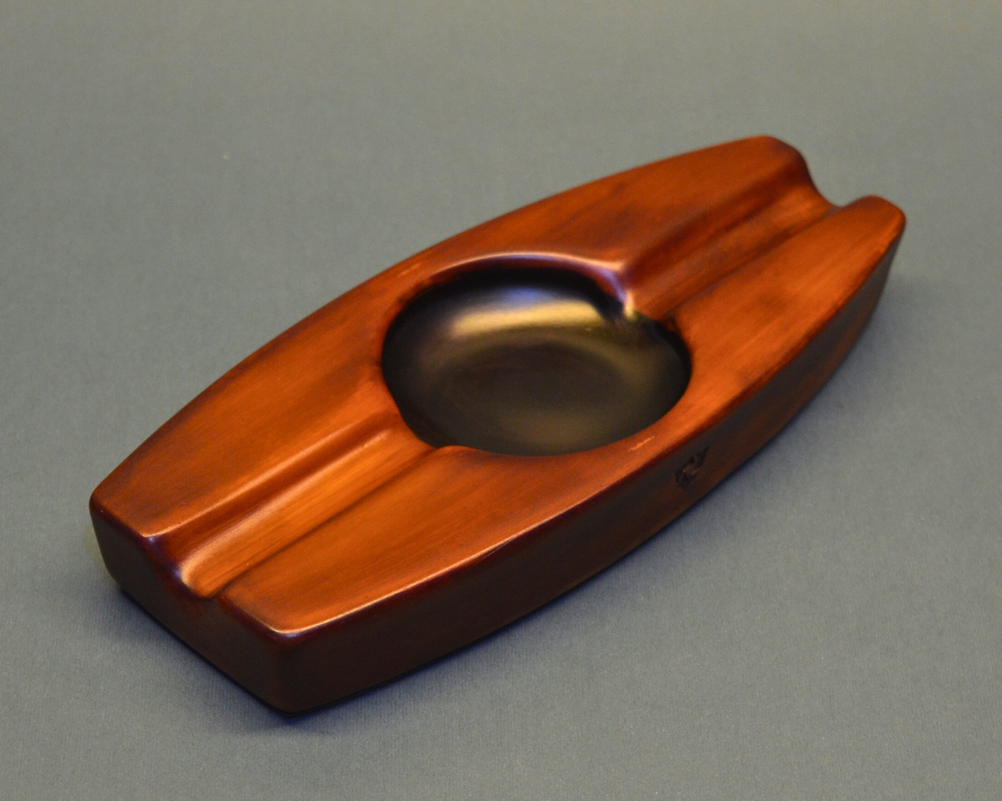 Wooden cigar ashtray on a gray background