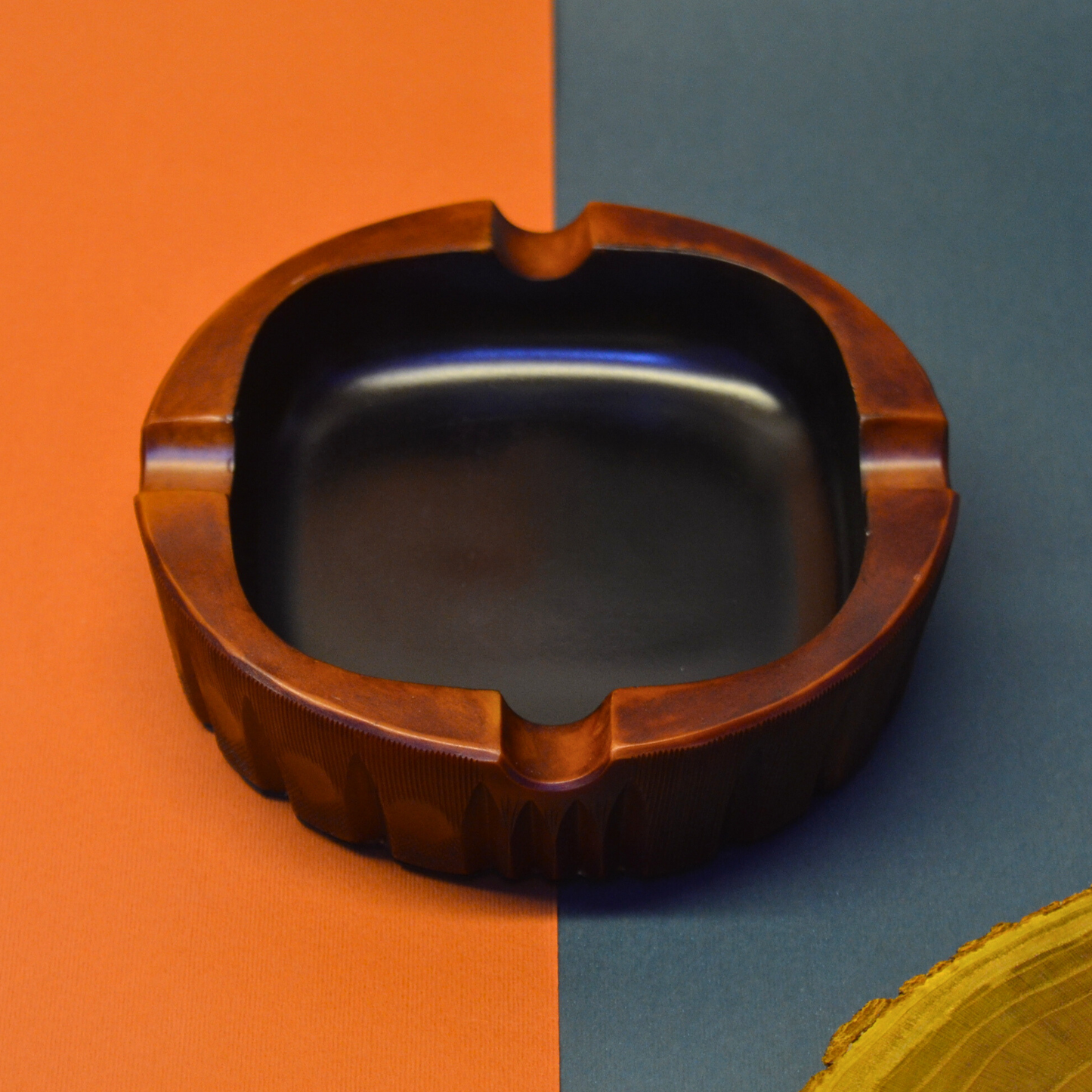 Wooden ashtray on a split orange and blue background