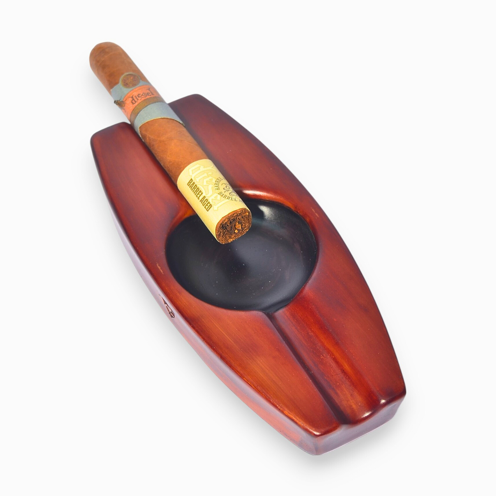 Cigar in a wooden boat-shaped ashtray on a white background