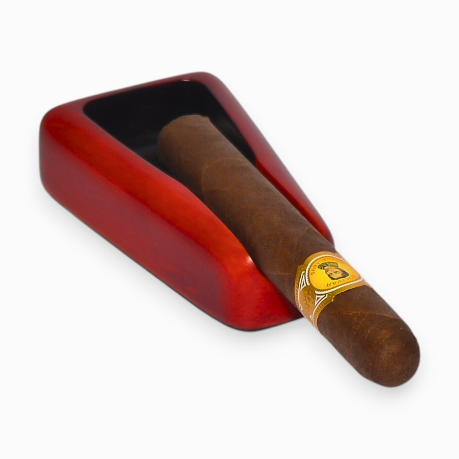 Cigar with a gold band in a red ashtray on a white background