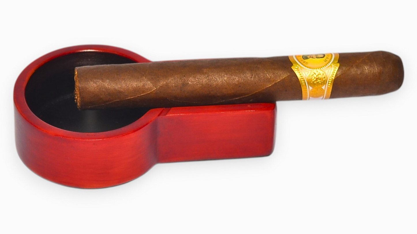 Red cigar ashtray with a cigar on a white background