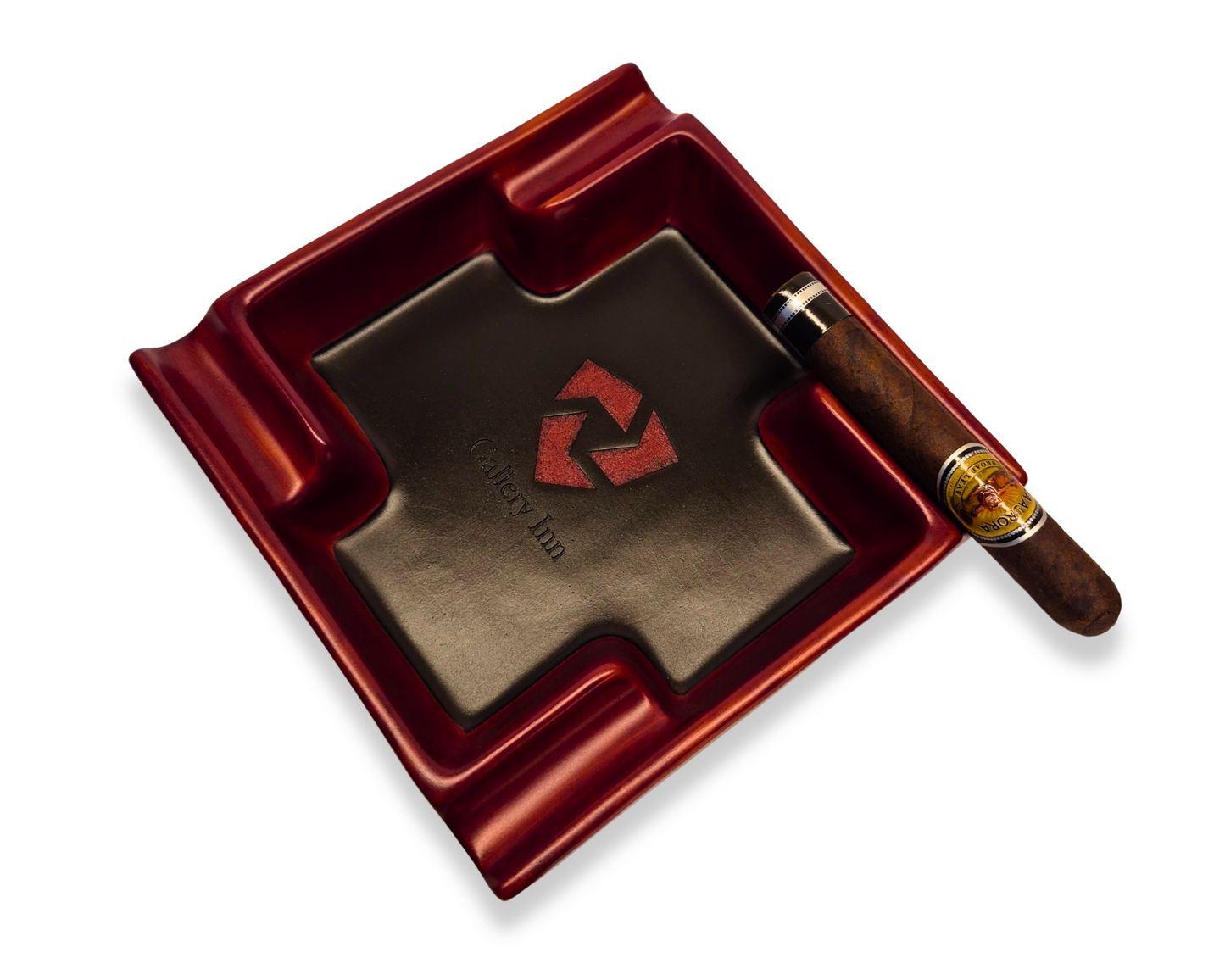 Red ashtray with a brown interior, featuring a logo, and a cigar on a white background.