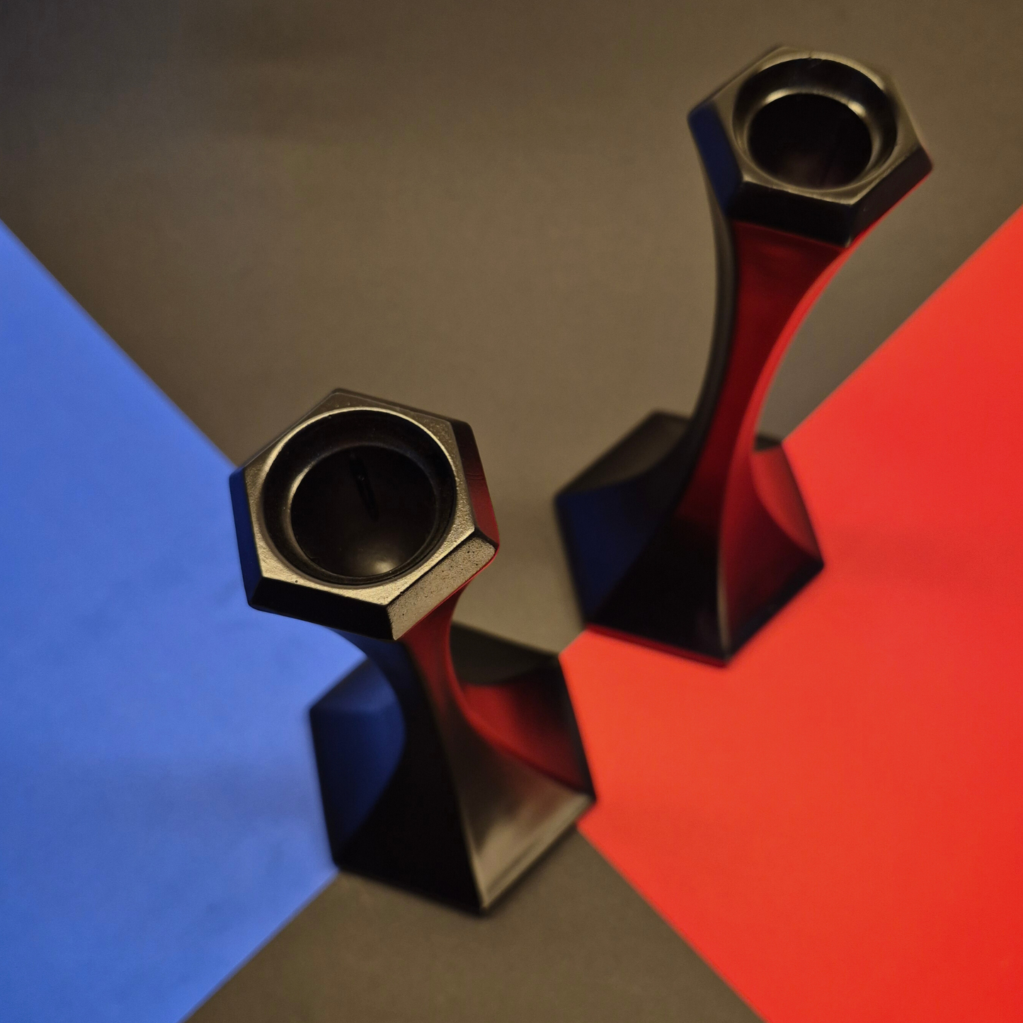 Metallic candle holders on a colorful geometric background