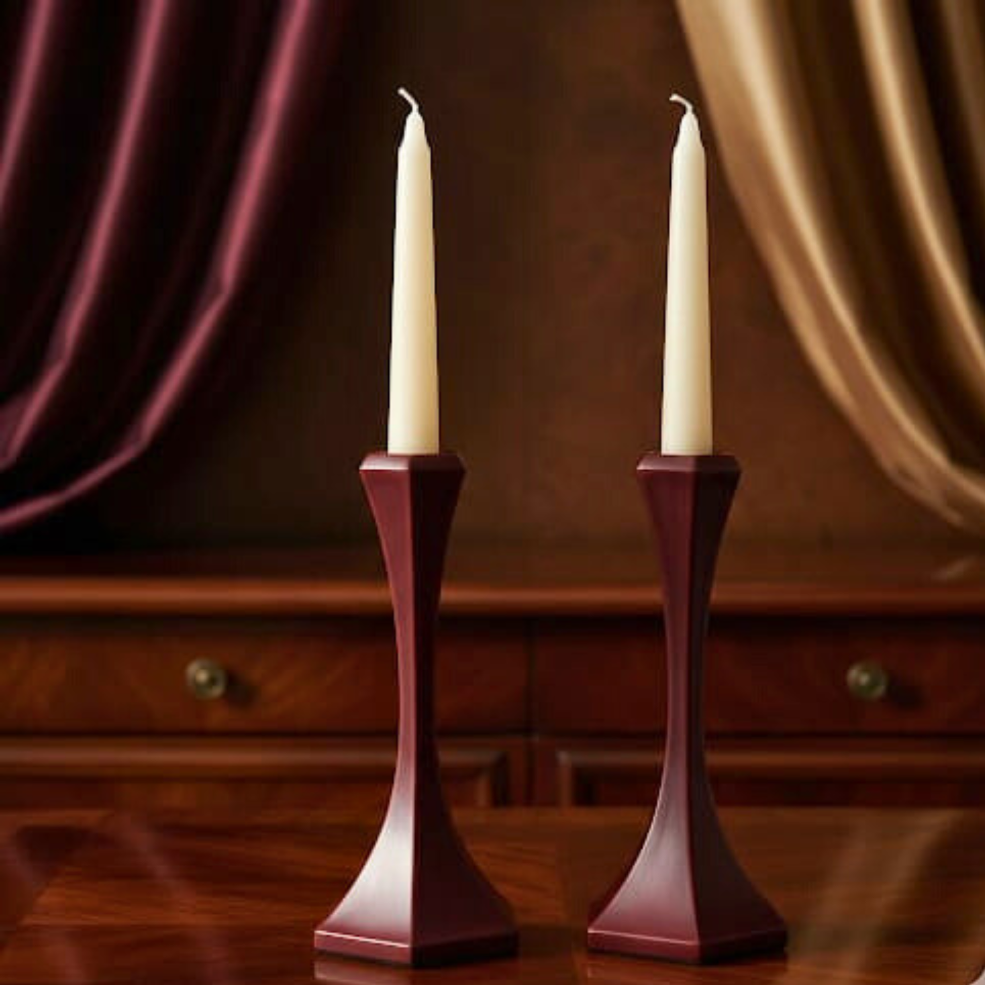 Two white candles in purple candlesticks on a wooden surface with a blurred background