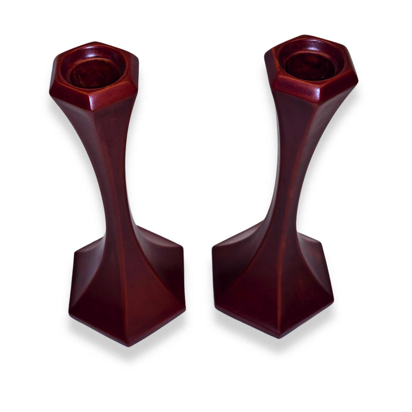 Two dark red candle holders on a white background