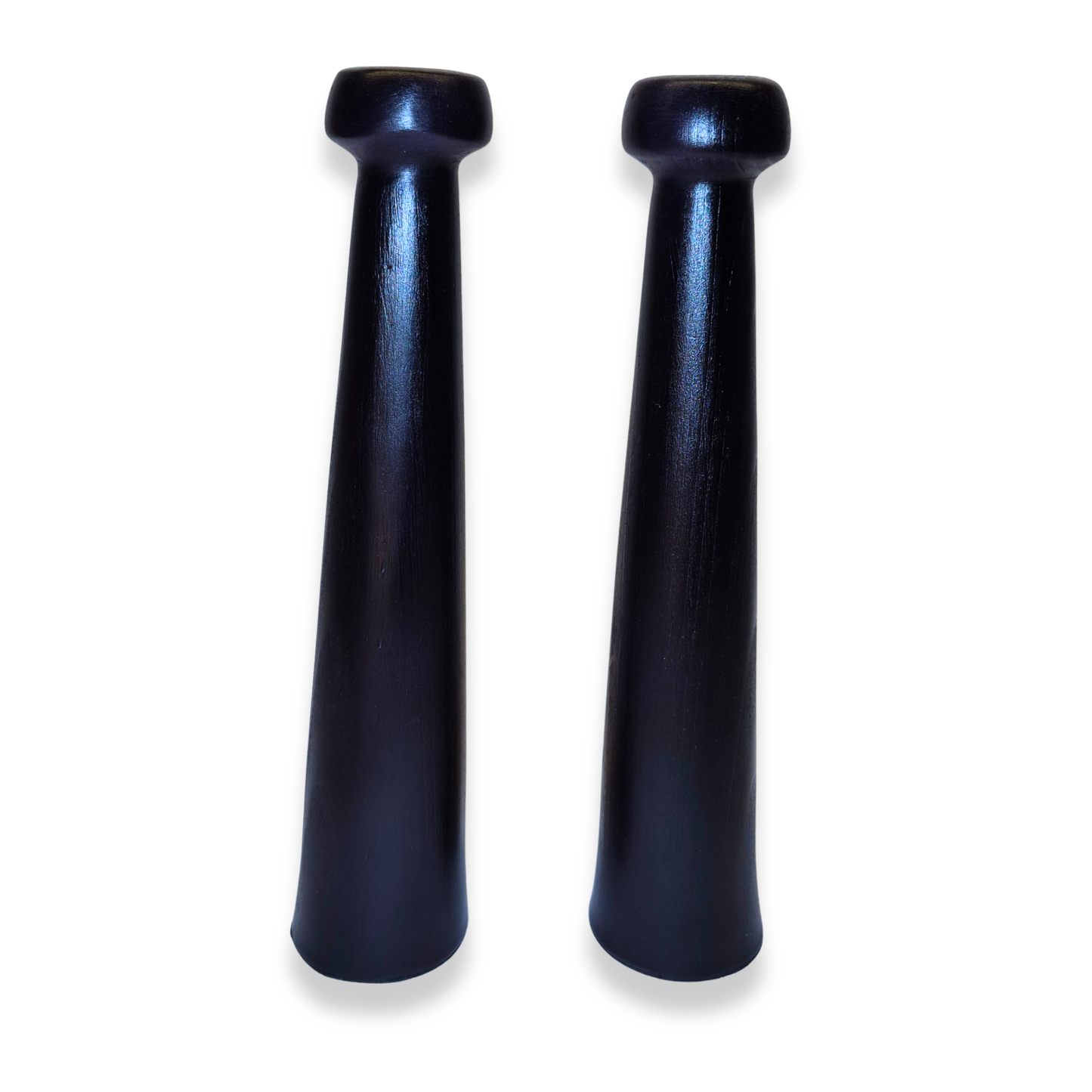 Two black ceramic pepper grinders on a white background