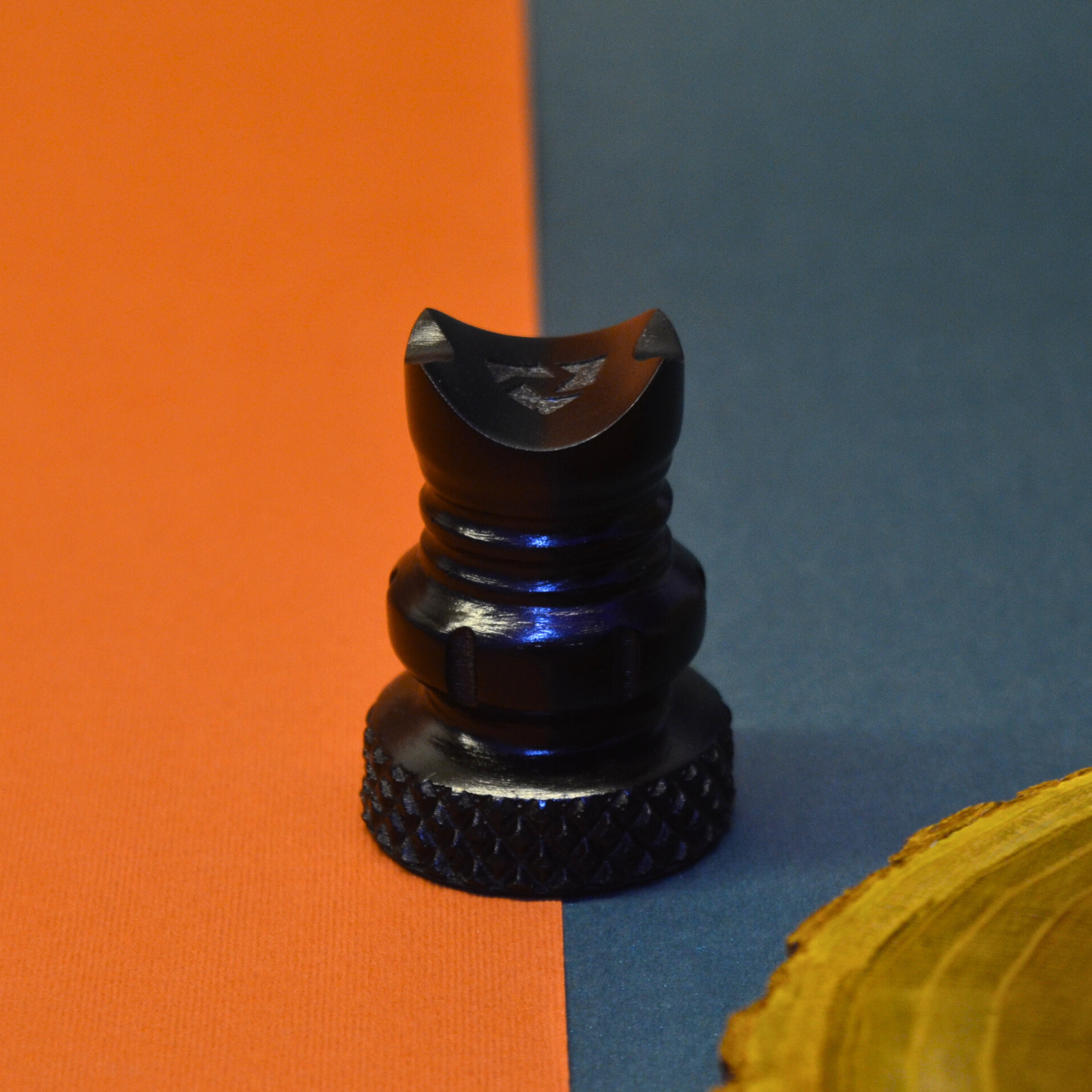 Black holder piece on an orange and blue background